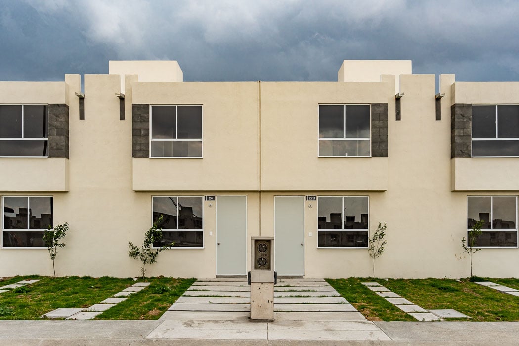 Casa de Ciudad Natura en Tizayuca. El cielo está nublado, hay césped y un medidor de electricidad. 