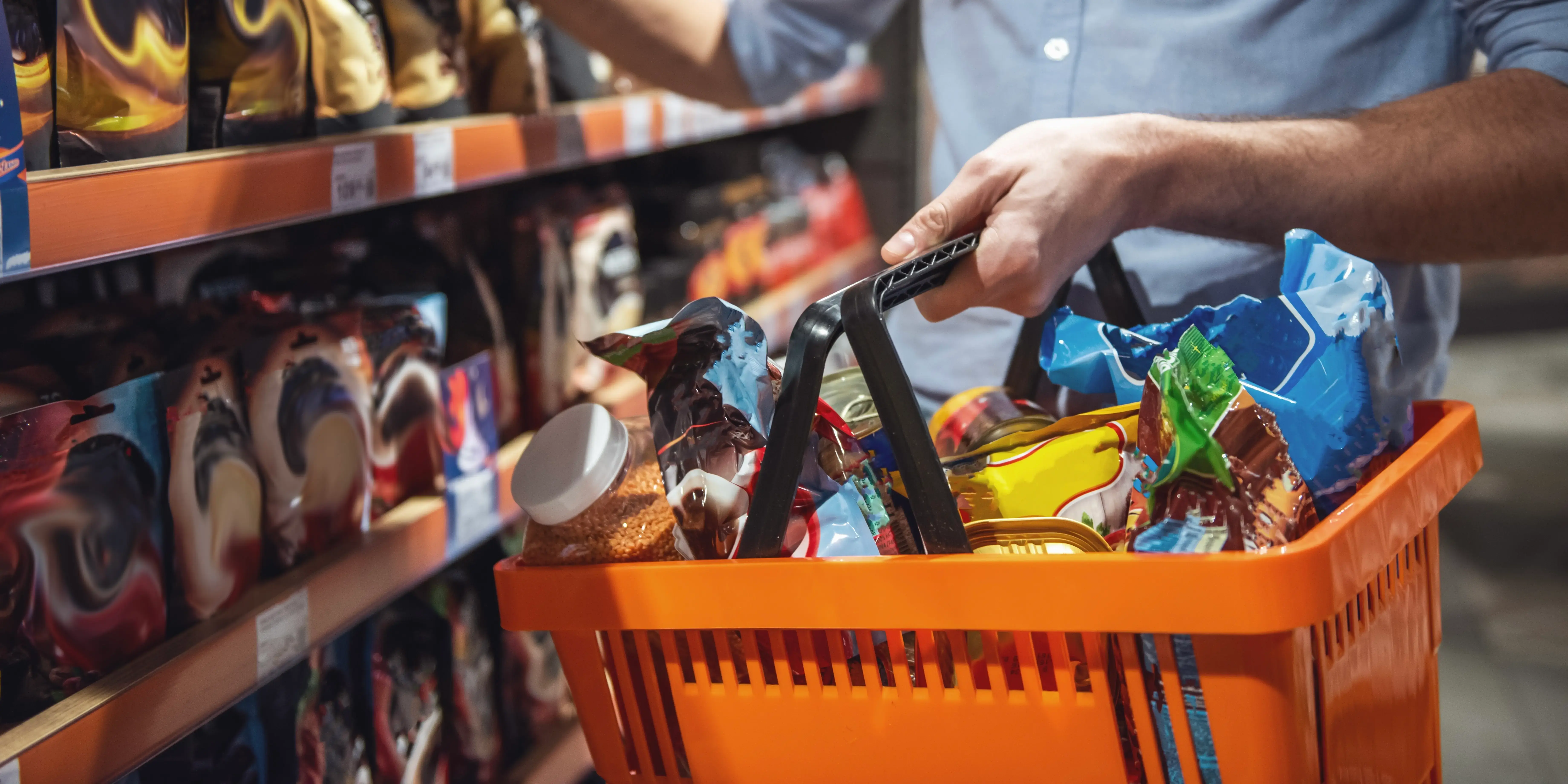 Hombre con una haciendo compras en el supermercado que es uno de sus gastos mensuales