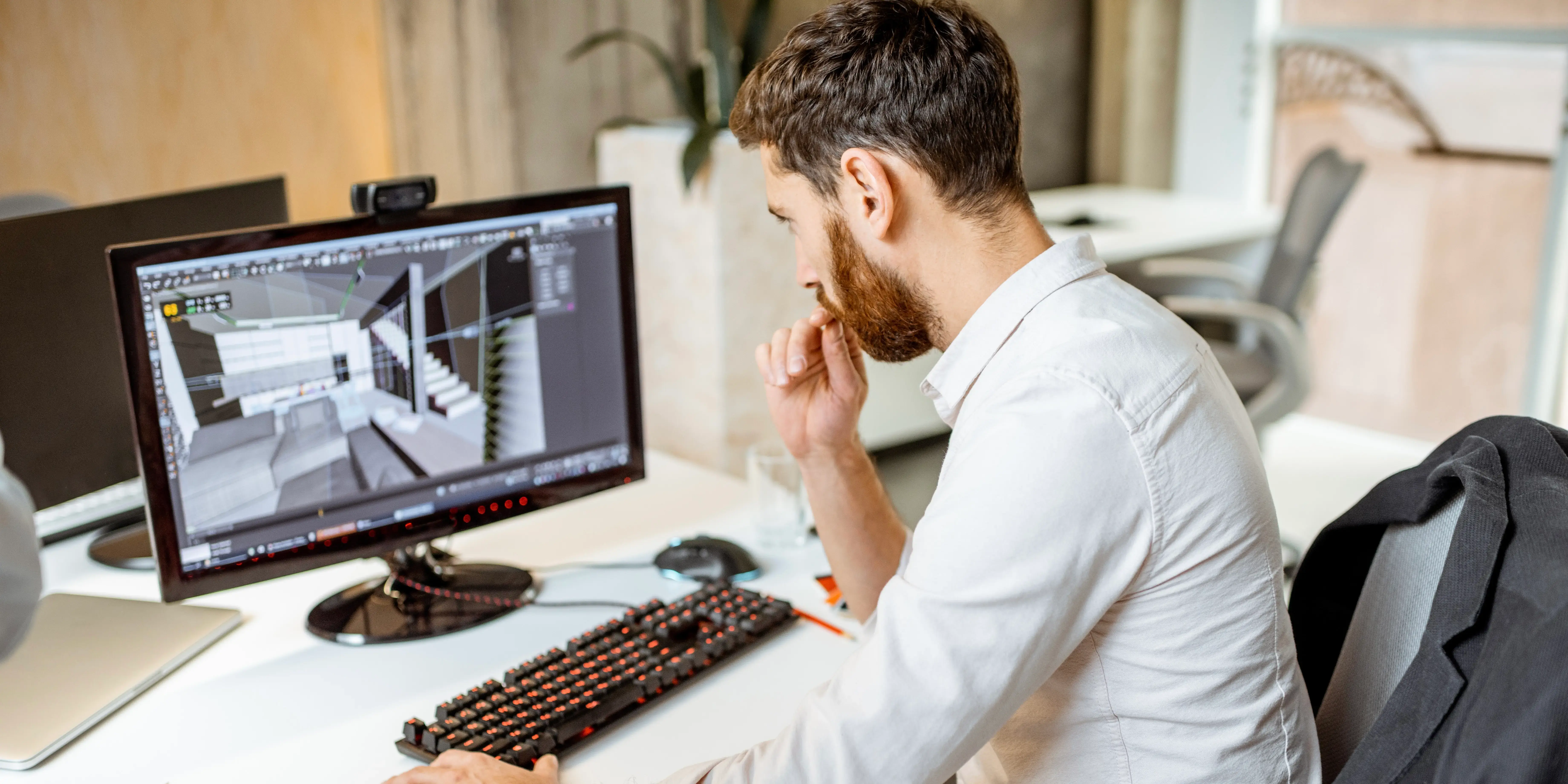 Hombre en una computadora viendo el render 3d de una casa de un desarrollo inmobiliario