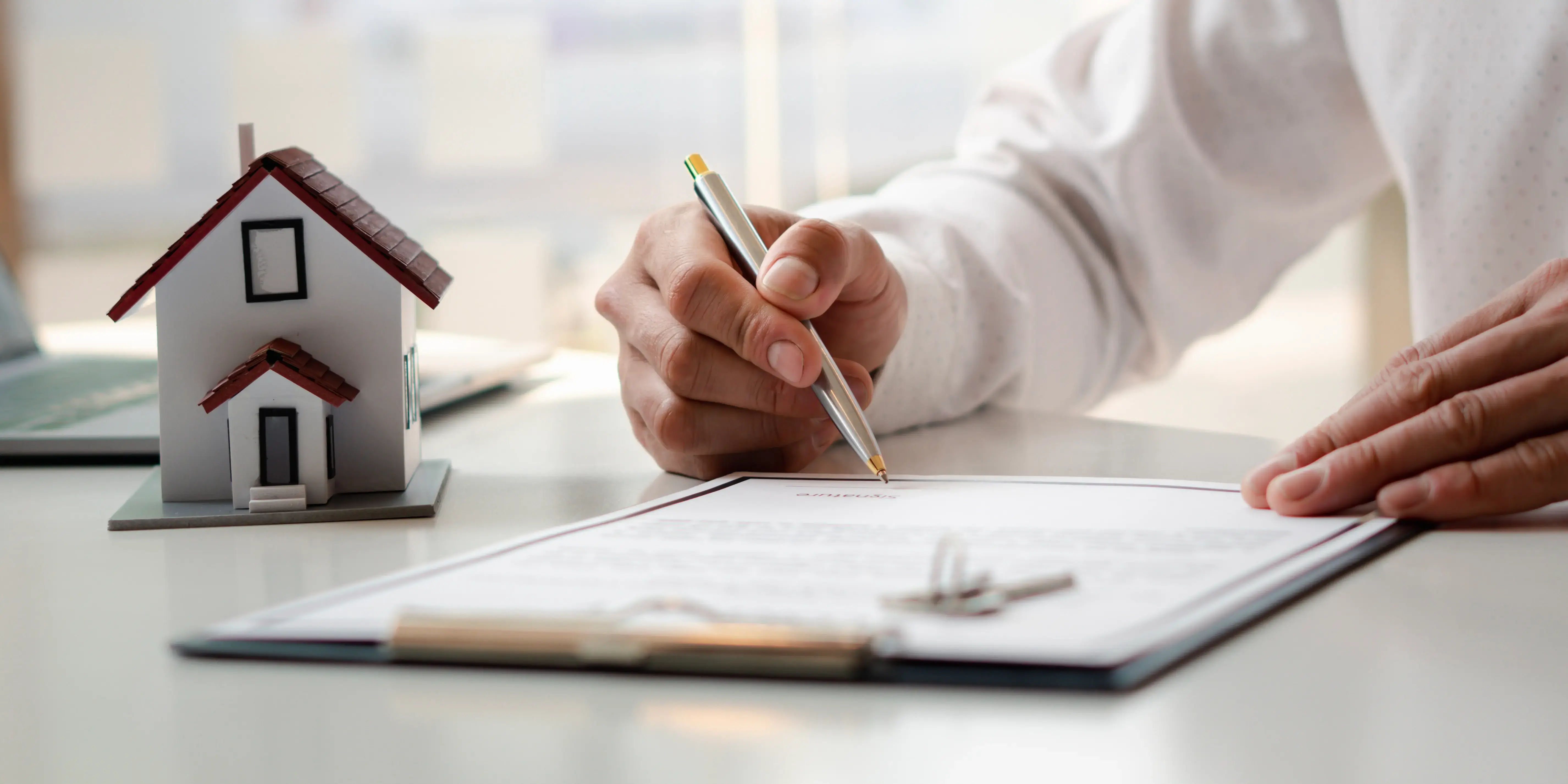 Hombre firmando el contrato de compraventa de su nueva casa, el paso 9 para comprar una casa