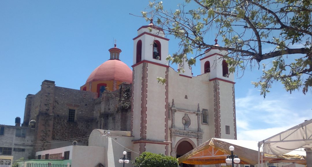 Iglesia de Huehuetoca, San Pedro y San Pablo Apostol. Hay árboles y carpas, incluso alumbrado público tipo colonial.