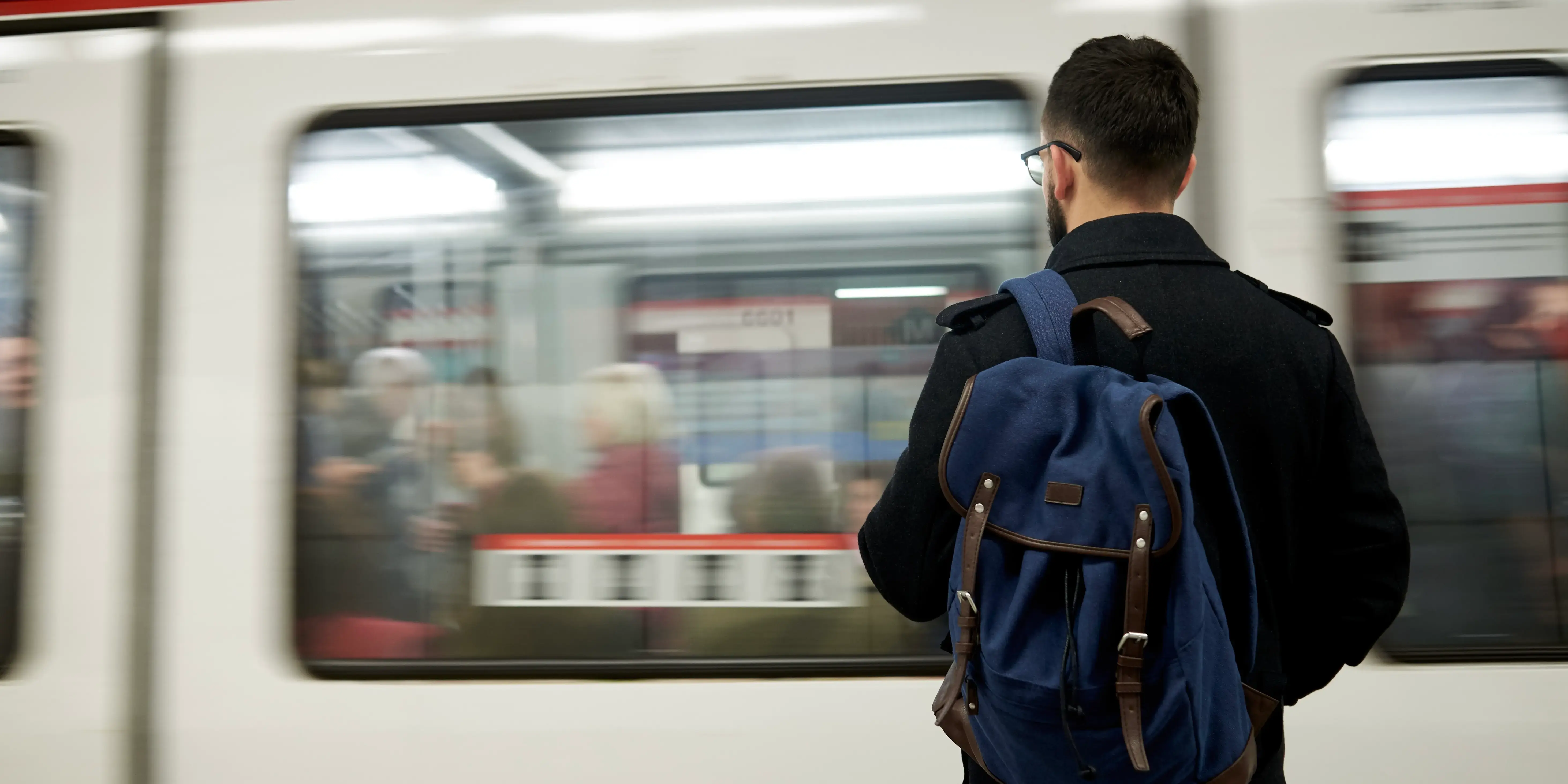 Joven que vive cerca del transporte público está parado frente al tren del metro