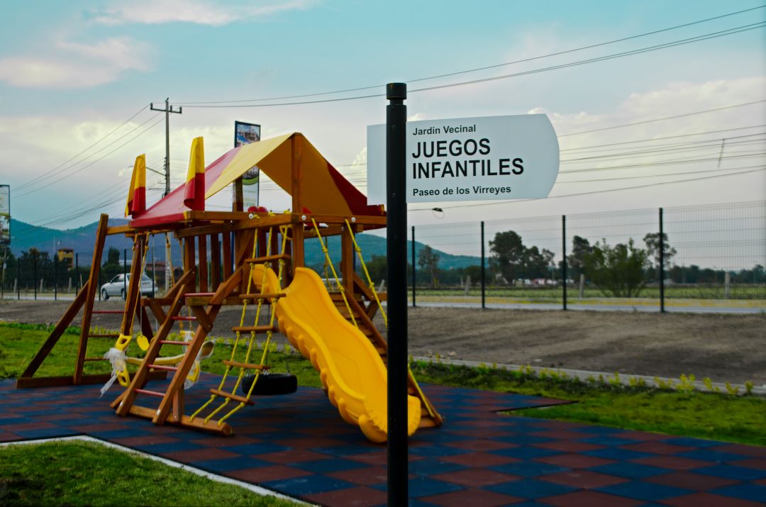 Letrero que dice Juegos Infantiles, es una amenidad para niños con juegos infantiles y suelo de goma.