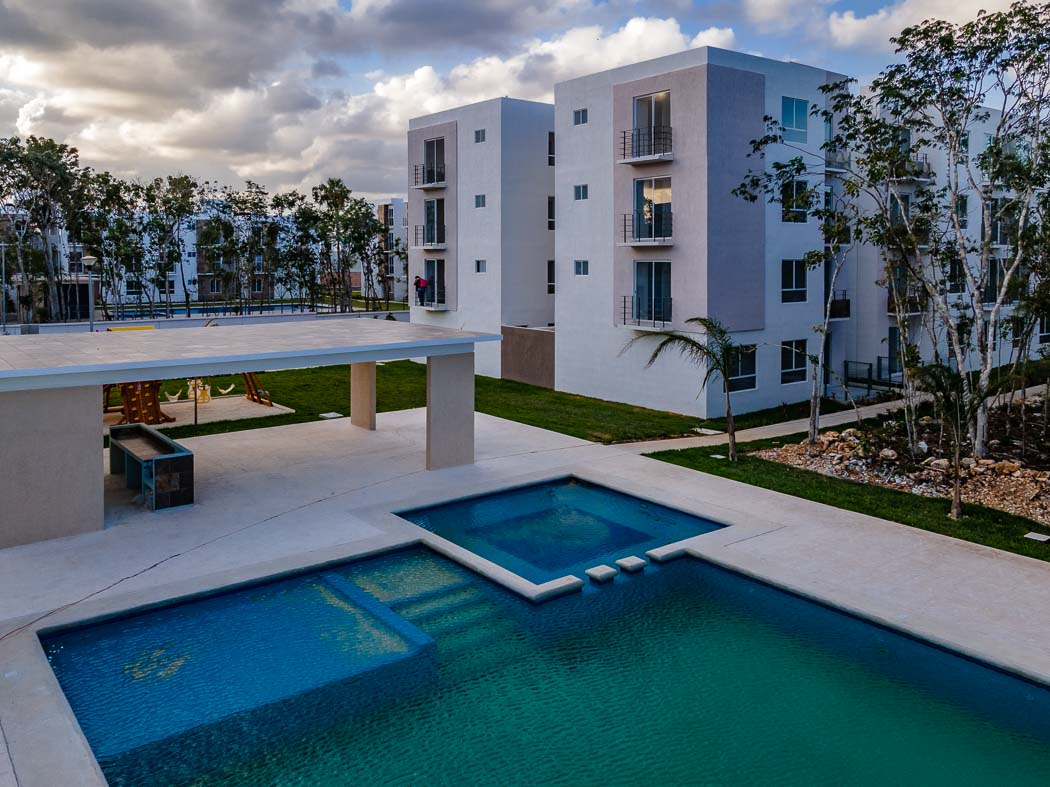 Casa de Palmas Turquesa en la Riviera Maya. al frente hay una alberca. Alrededores con vegetación.