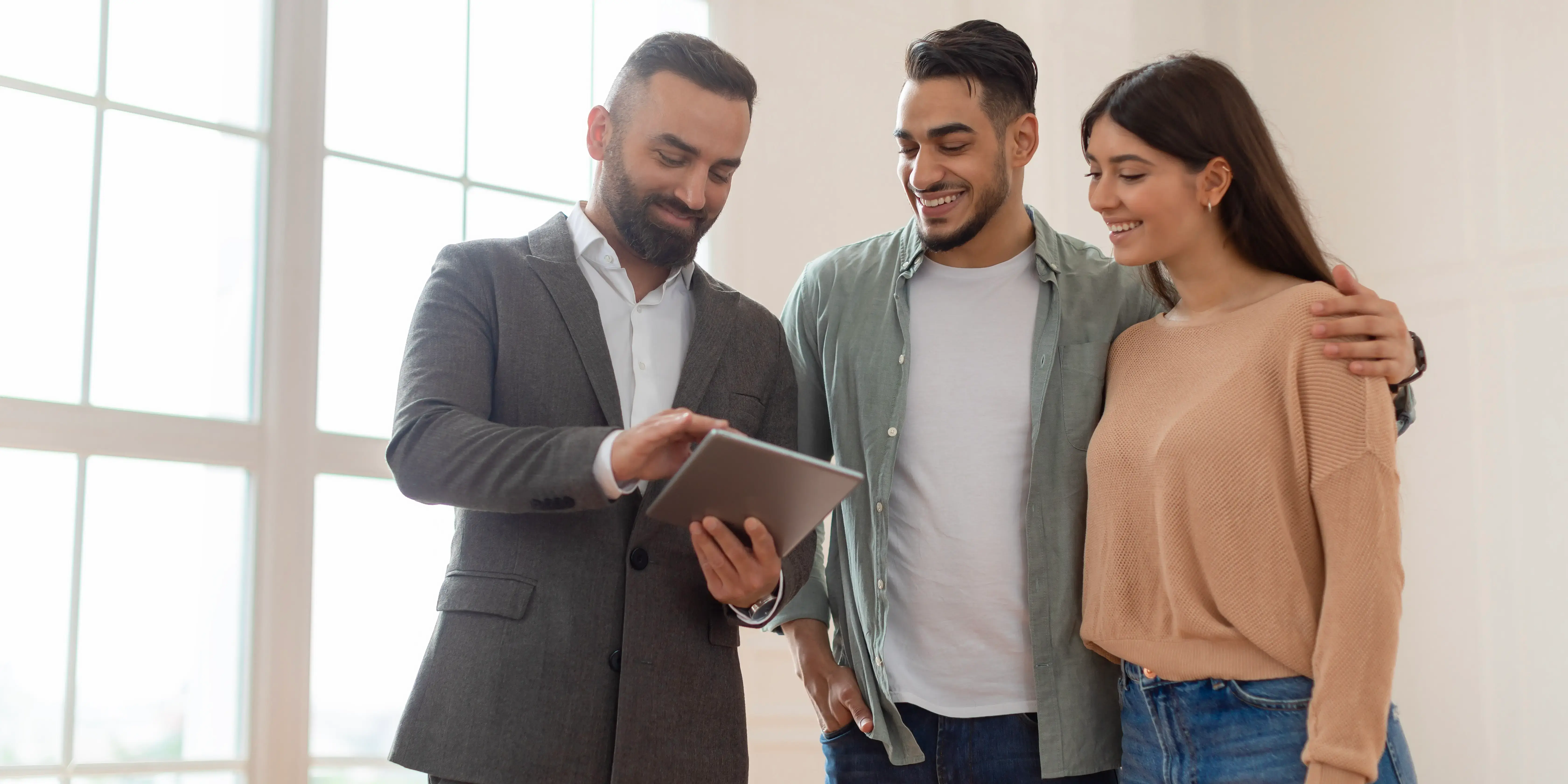 Pareja preguntando a asesor inmobiliario los beneficios extras de las promociones inmobiliarias