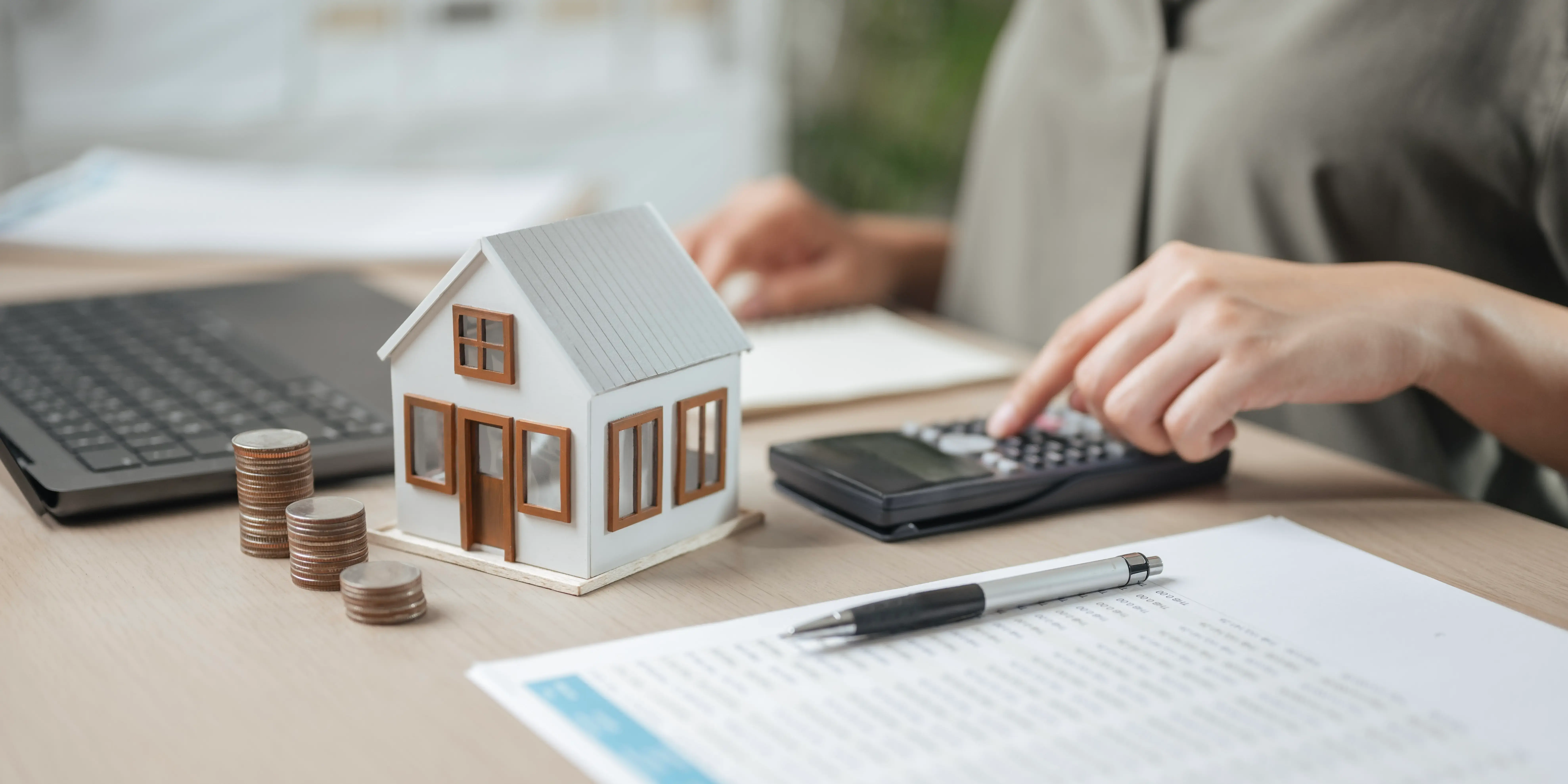 Persona con una calculadora y unos documentos viendo cuánto cuesta escriturar una casa