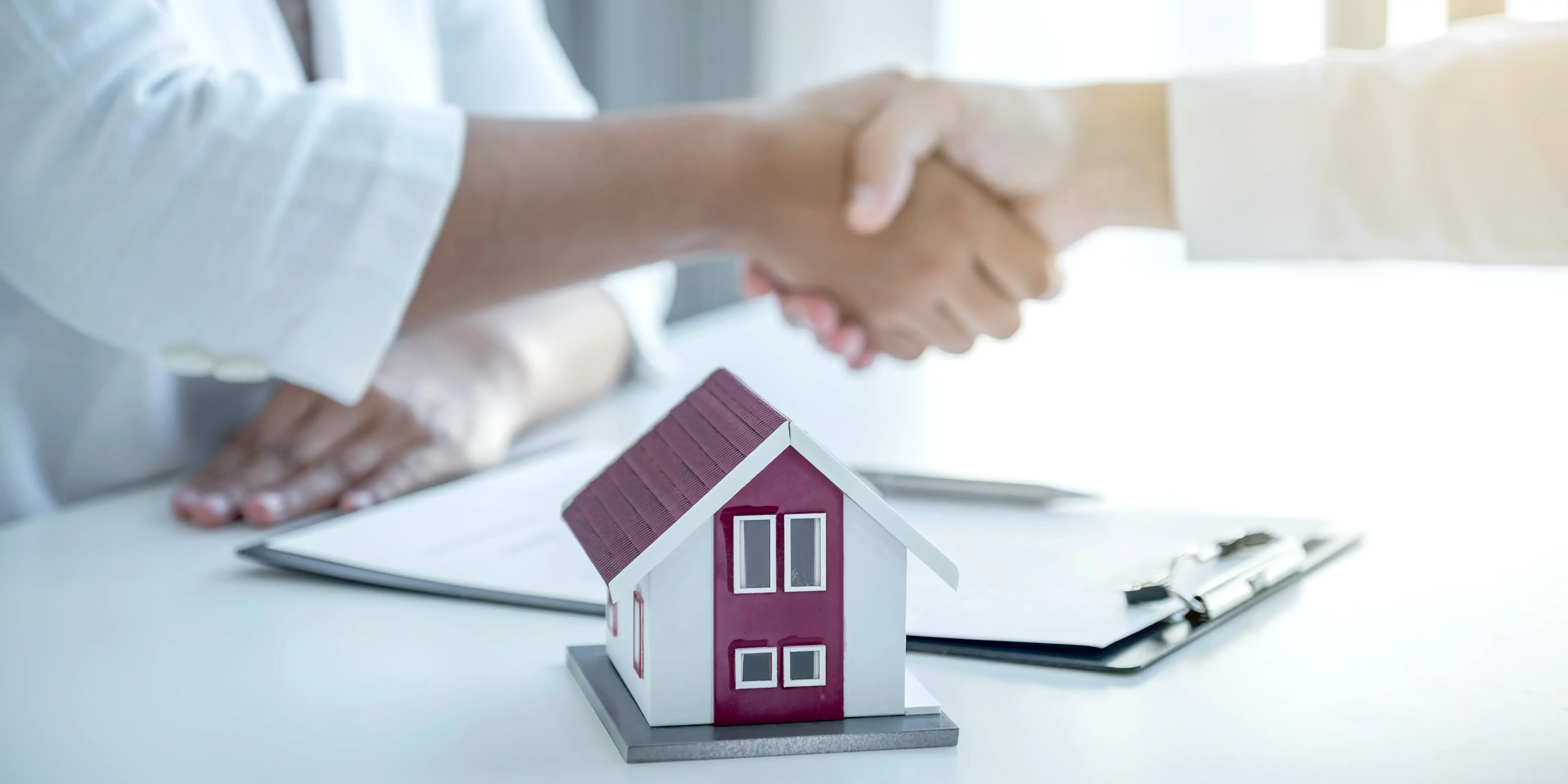 Personas se dan la mano después de firmar un contrato del descuento Infonavit 75