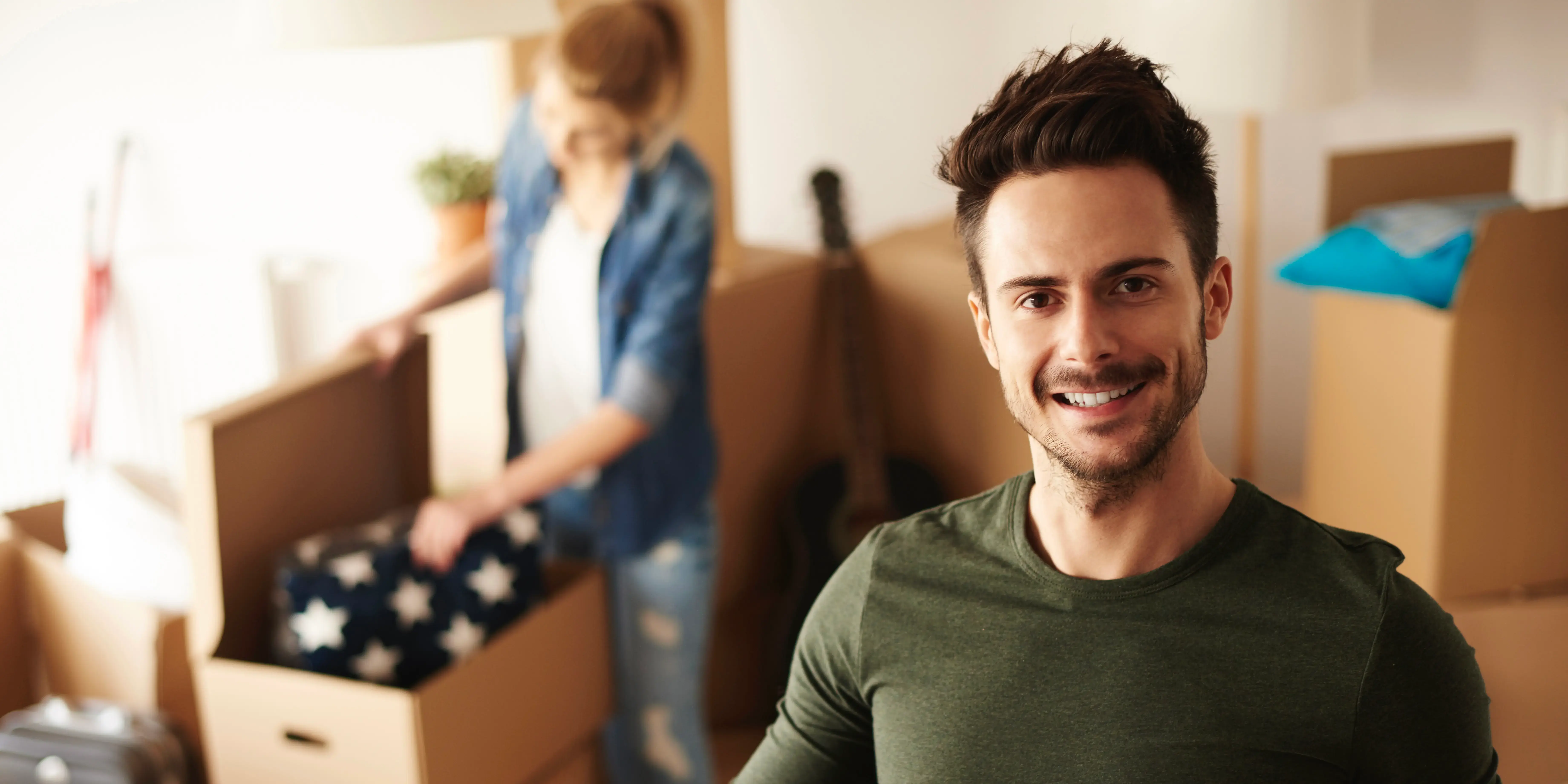 Pareja con cajas de mudanza. Invertir en inmuebles
