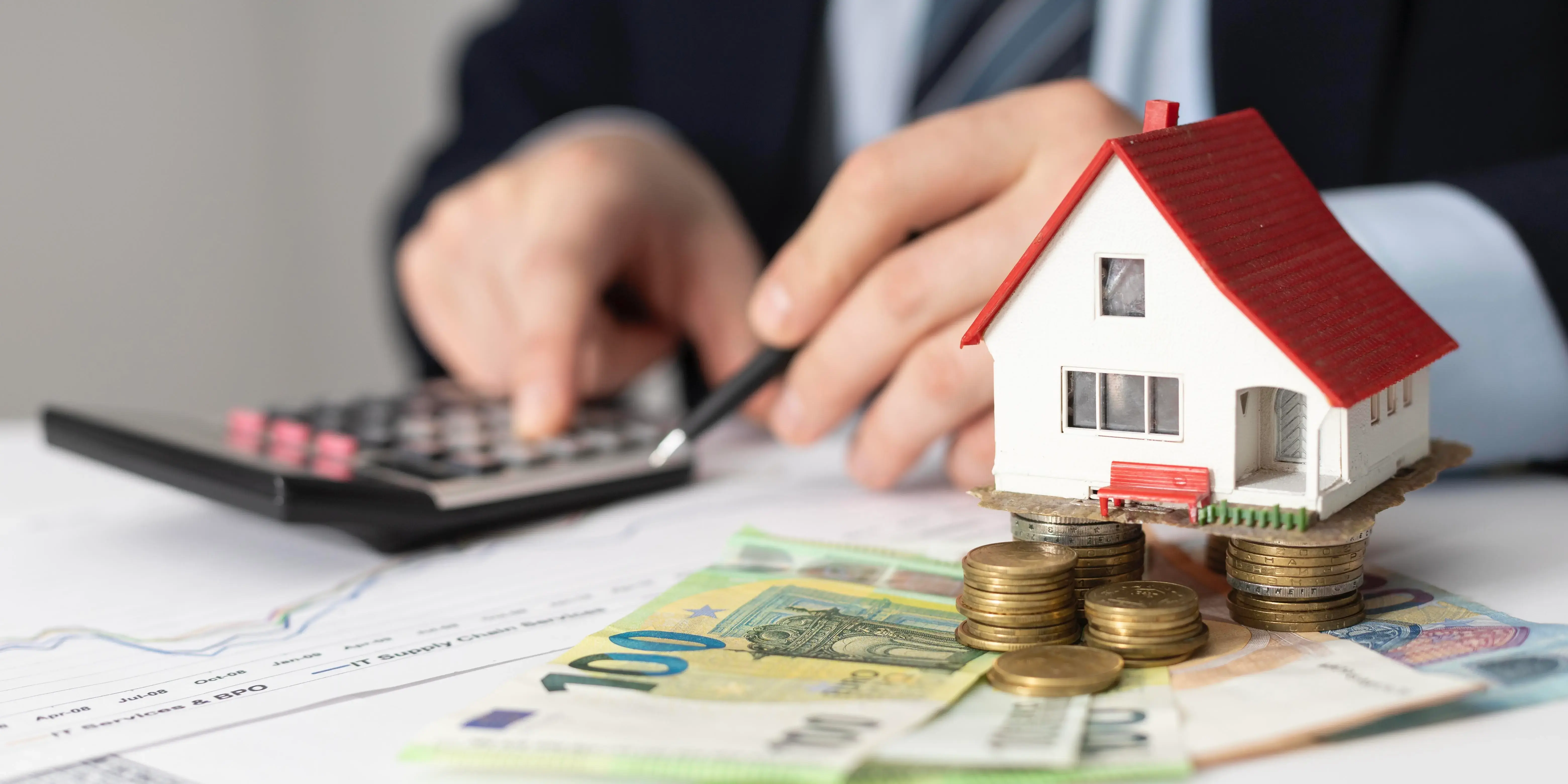 Persona con calculadora y dinero con una casa de fondo. Crédito hipotecario accesible