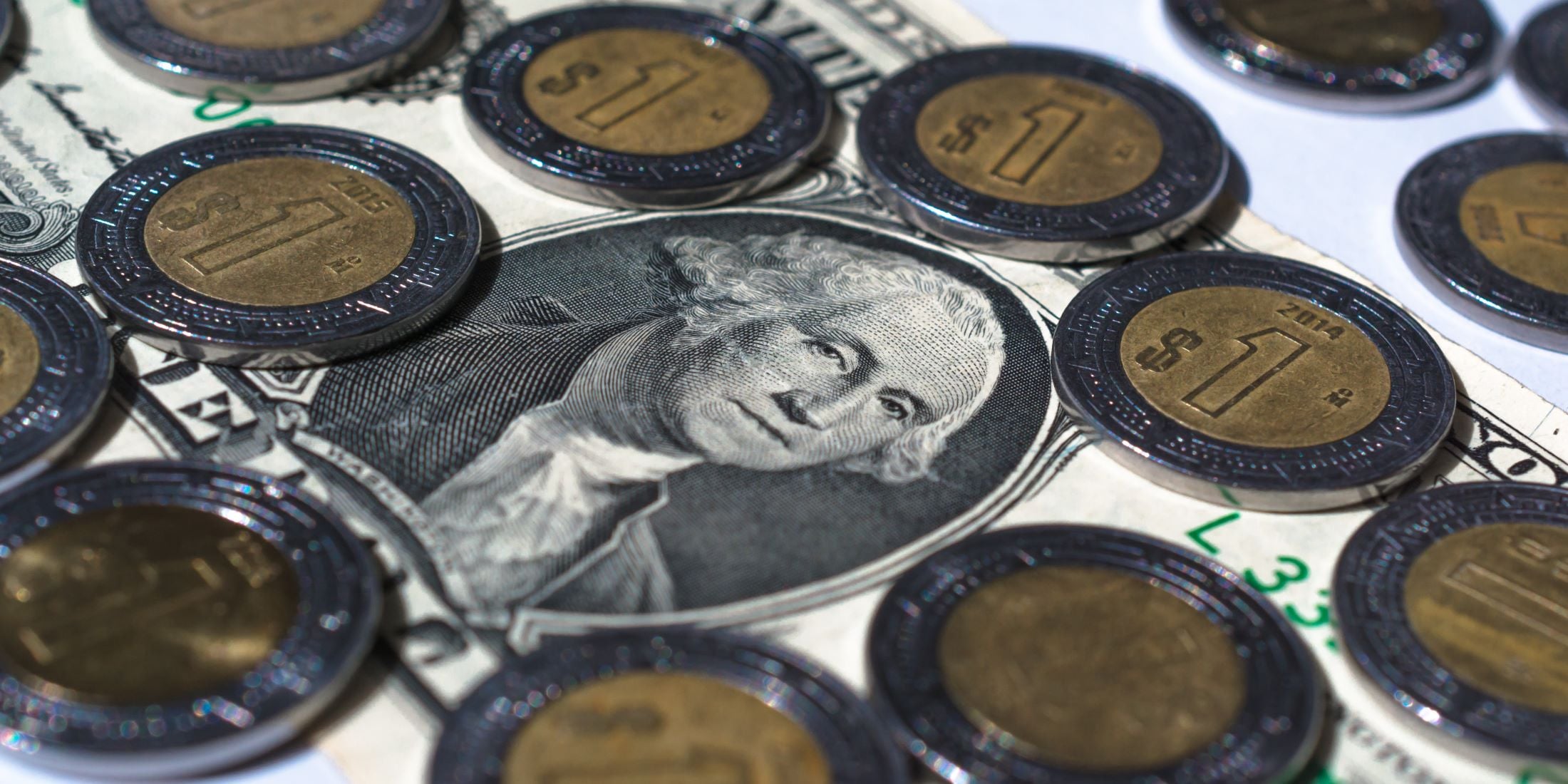 ¿Puedo comprar una casa de Infonavit si vivo en Estados Unidos? billete de un dólar rodeado de pesos mexicanos.