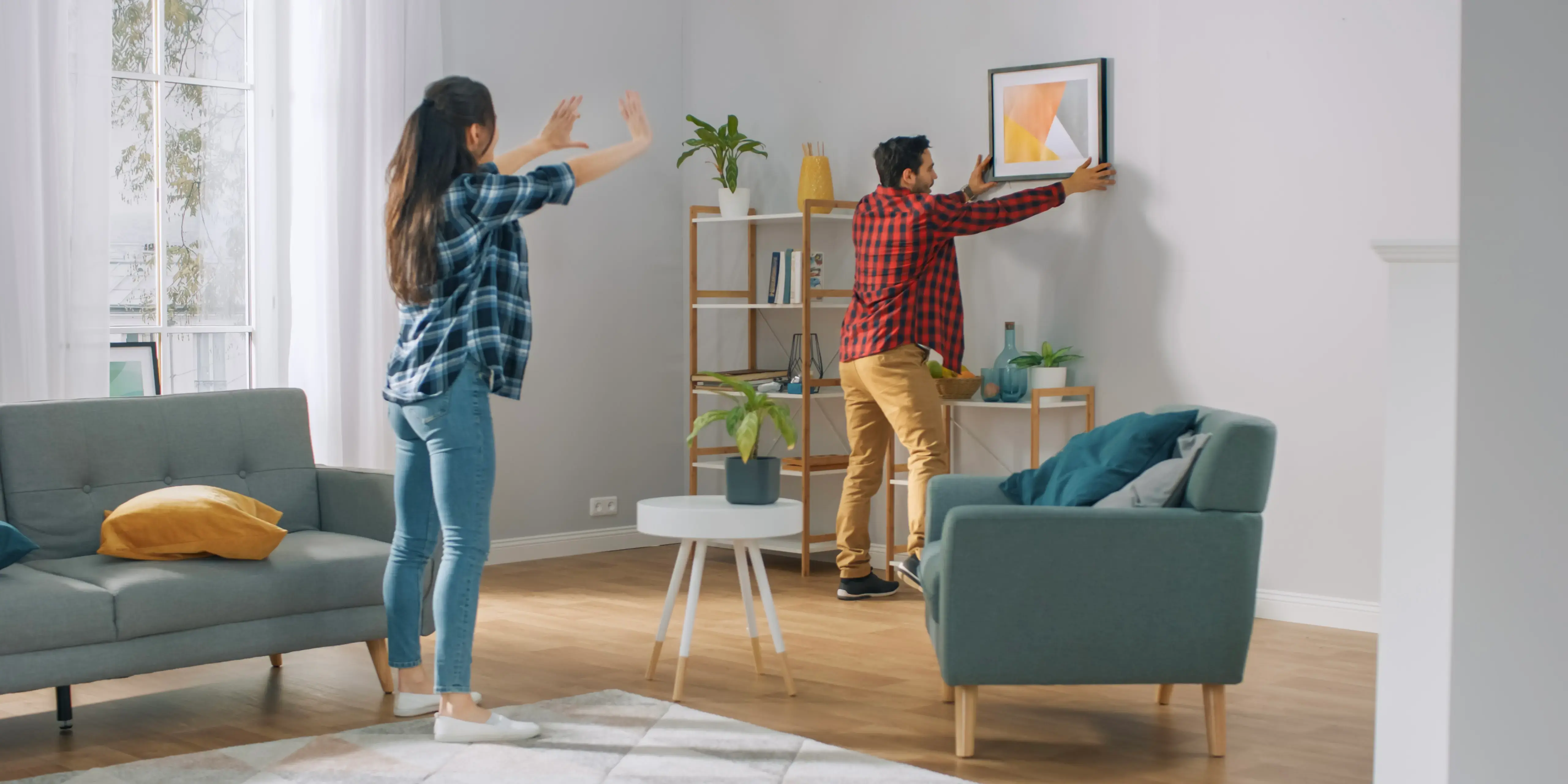Pareja decorando la sala de su casa. Tu espacio, tu paz