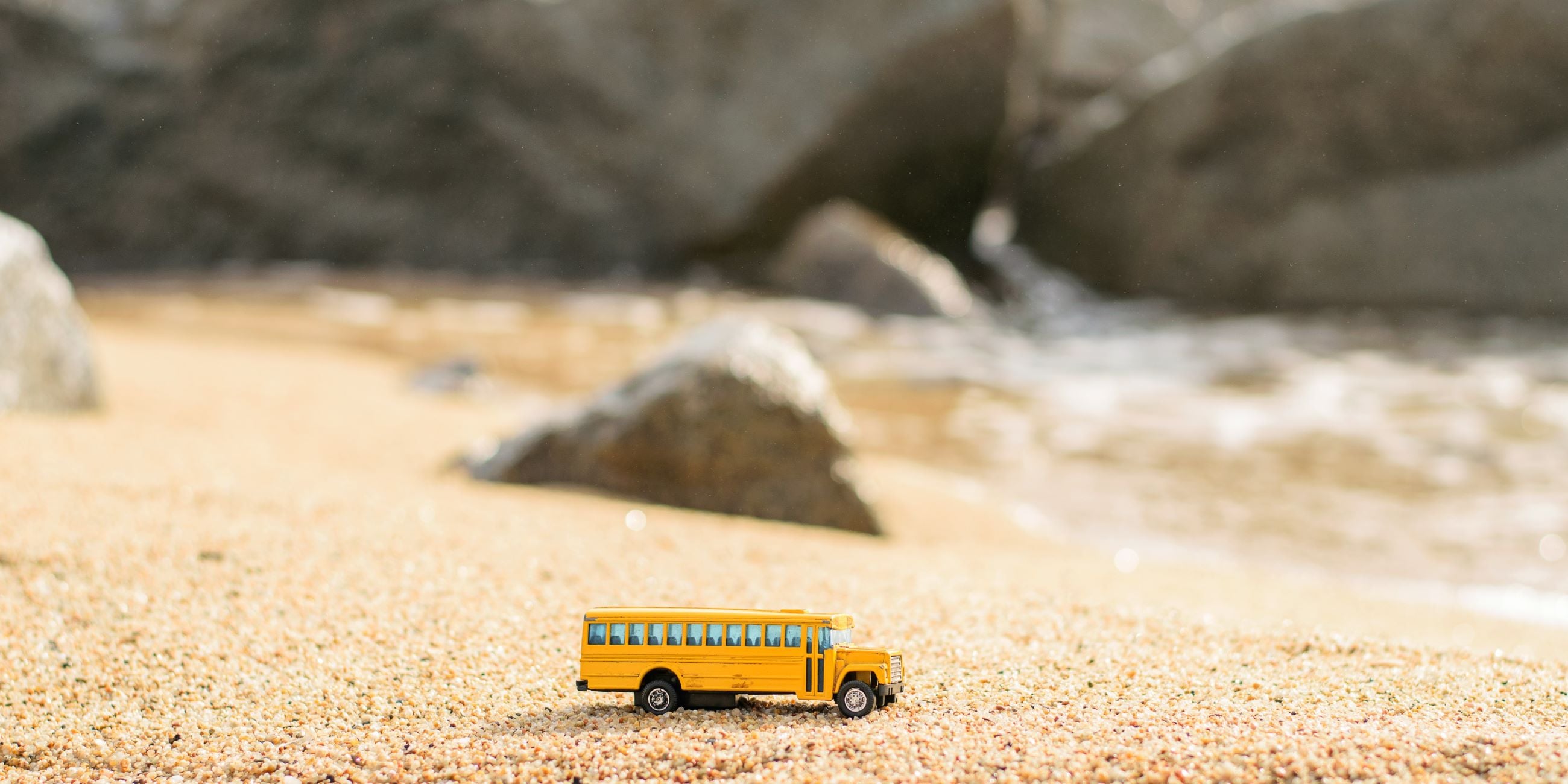 Un autobús de juguete en la playa.