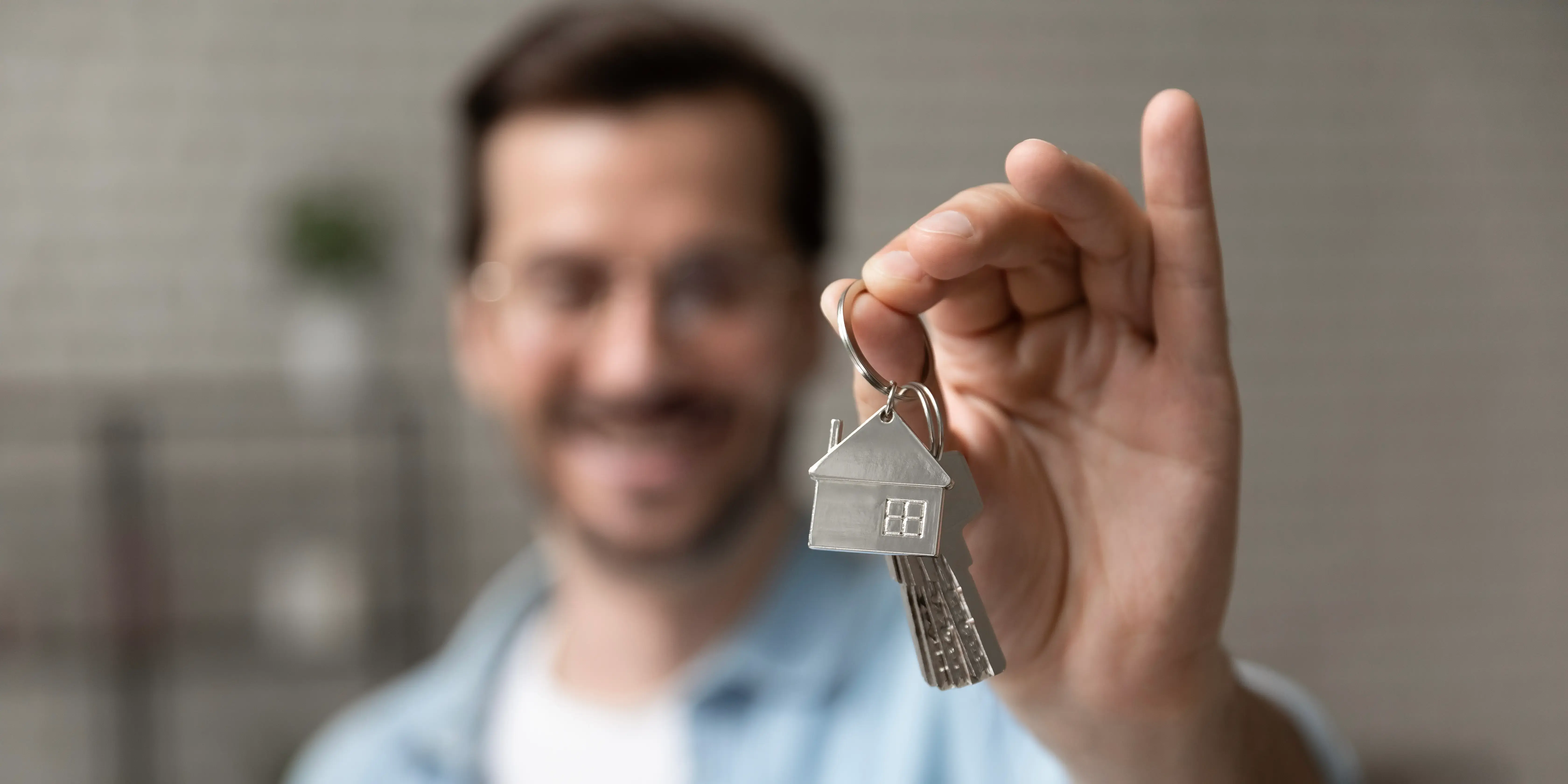 Hombre sosteniendo llaves de una casa. Tener tu propio espacio