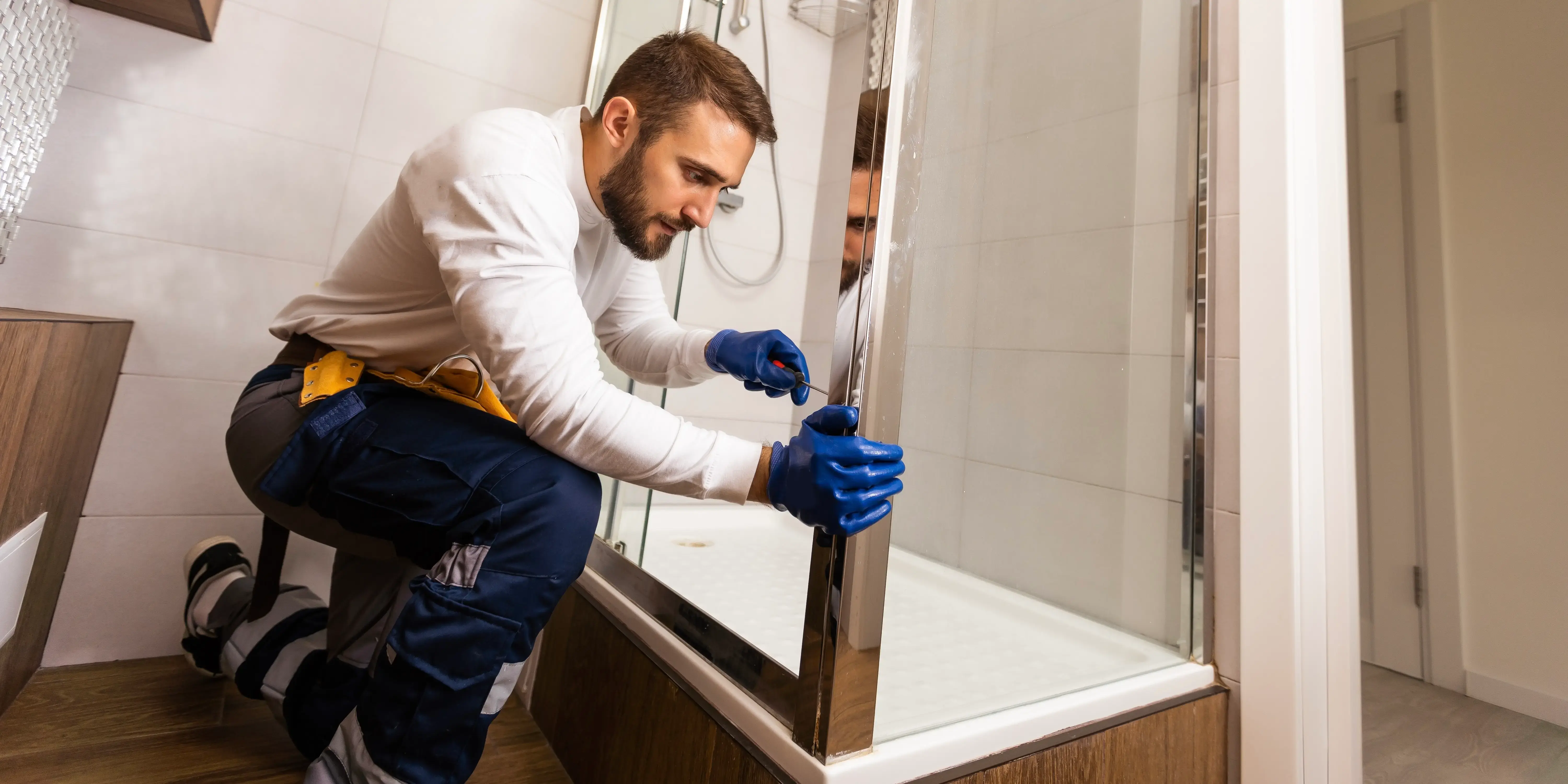 Hombre arreglando cancel del baño. Remodelar tu casa