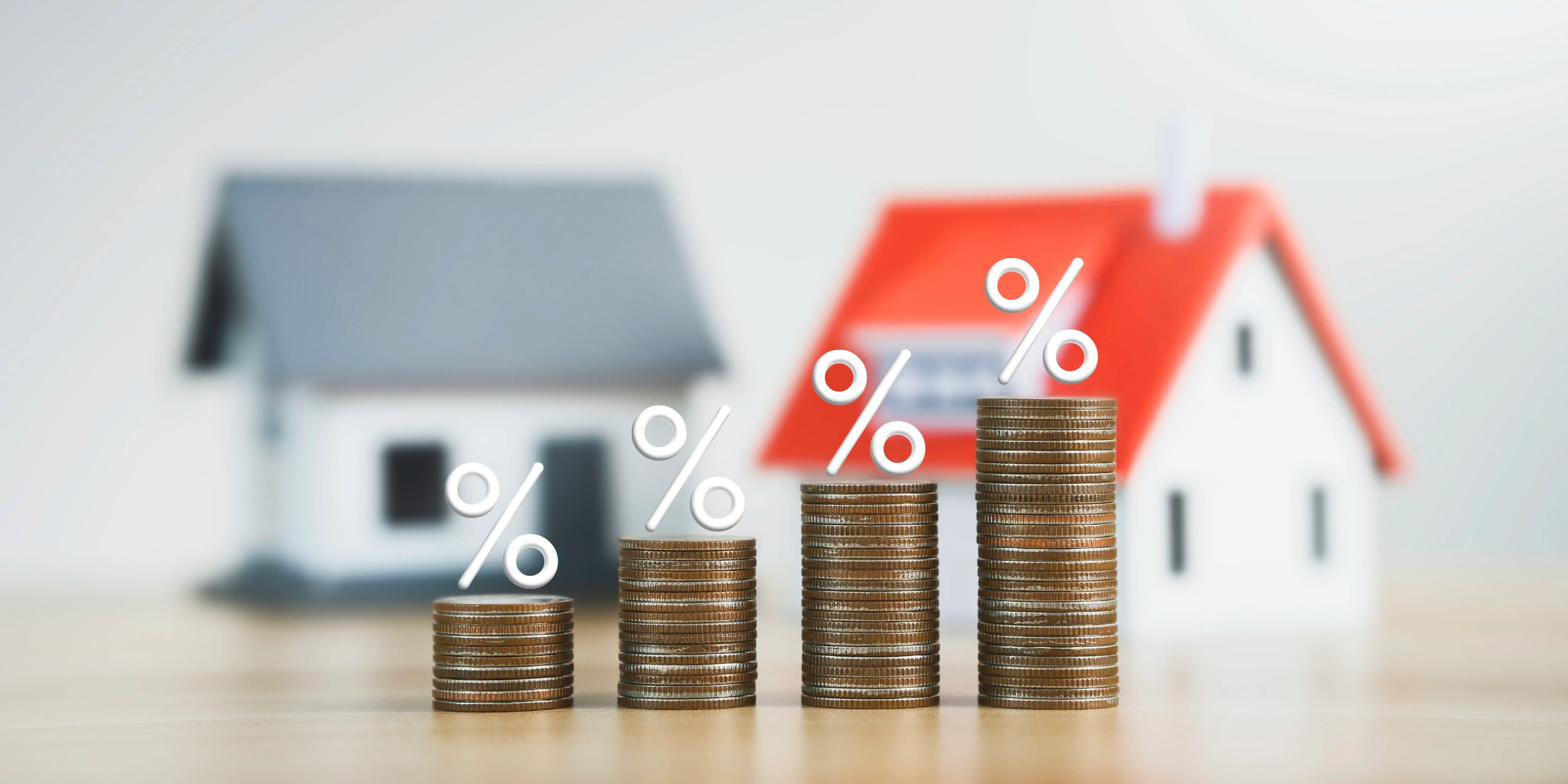 Casas con torres de moneda en aumento, tasa de interés. Crédito hipotecario y autofinanciamiento