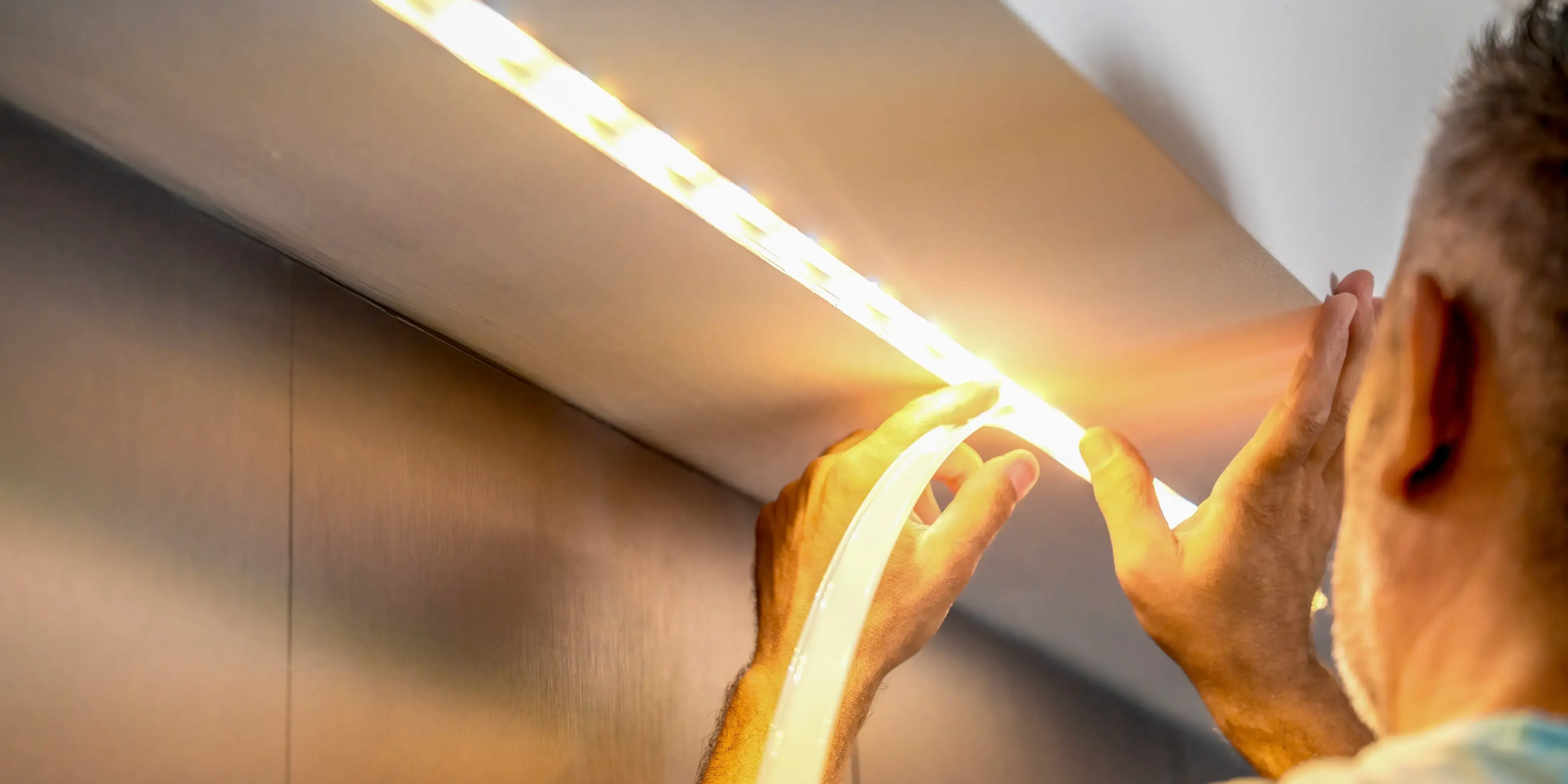 Hombre colocando tira led. Iluminación económica