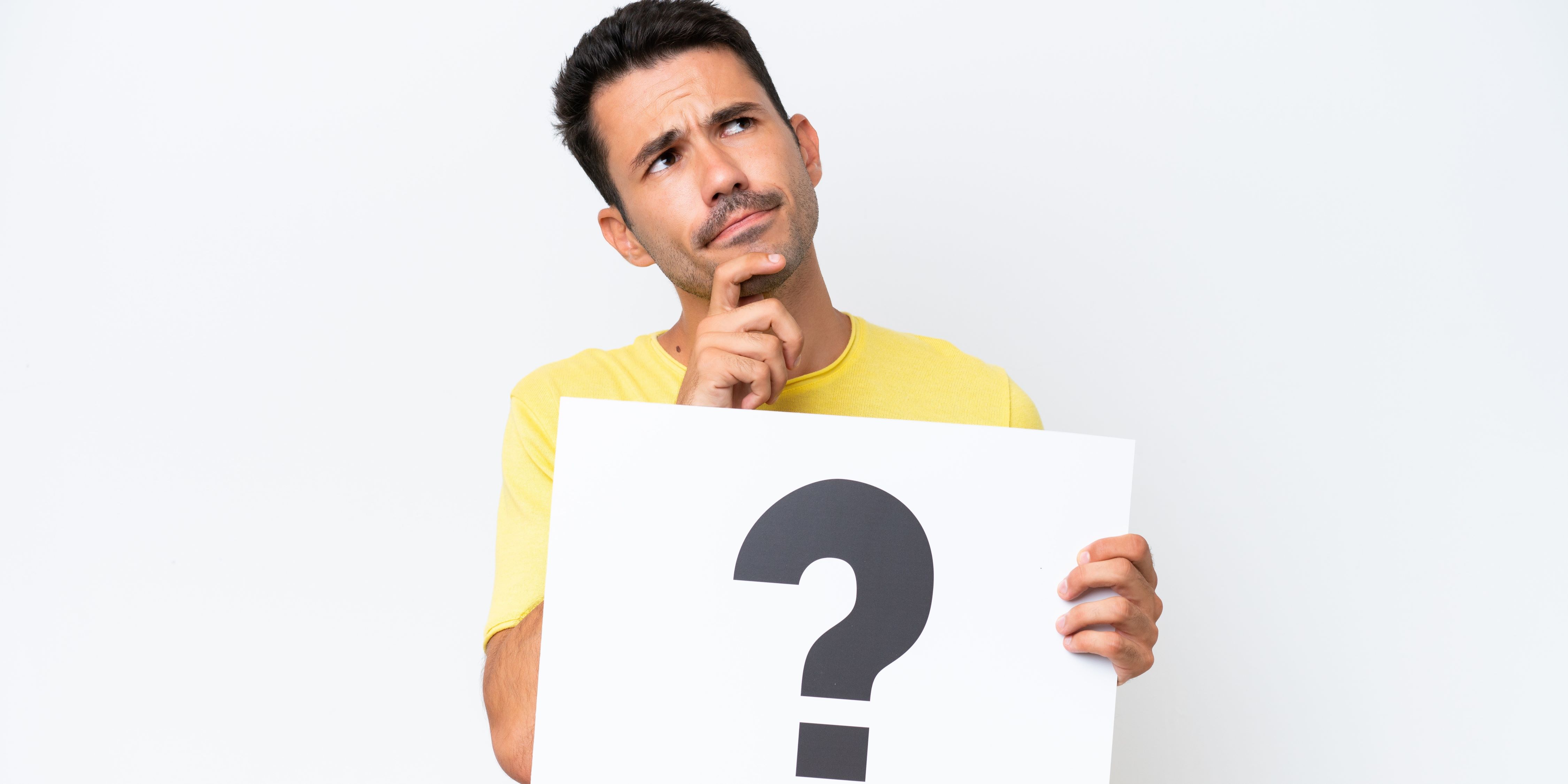 Un hombre está pensando qué opción le conviene más. Sostiene un cartel con un signo de interrogación.