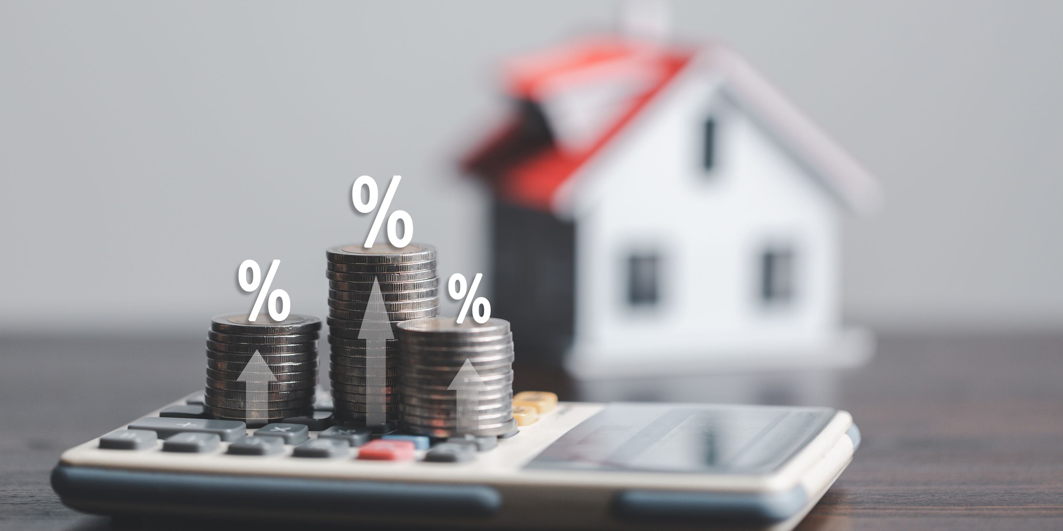 ¿No alcanza para una casa? Descubre qué hacer con tu primer crédito Infonavit. Calculadora y signos de porcentajes en la mesa.