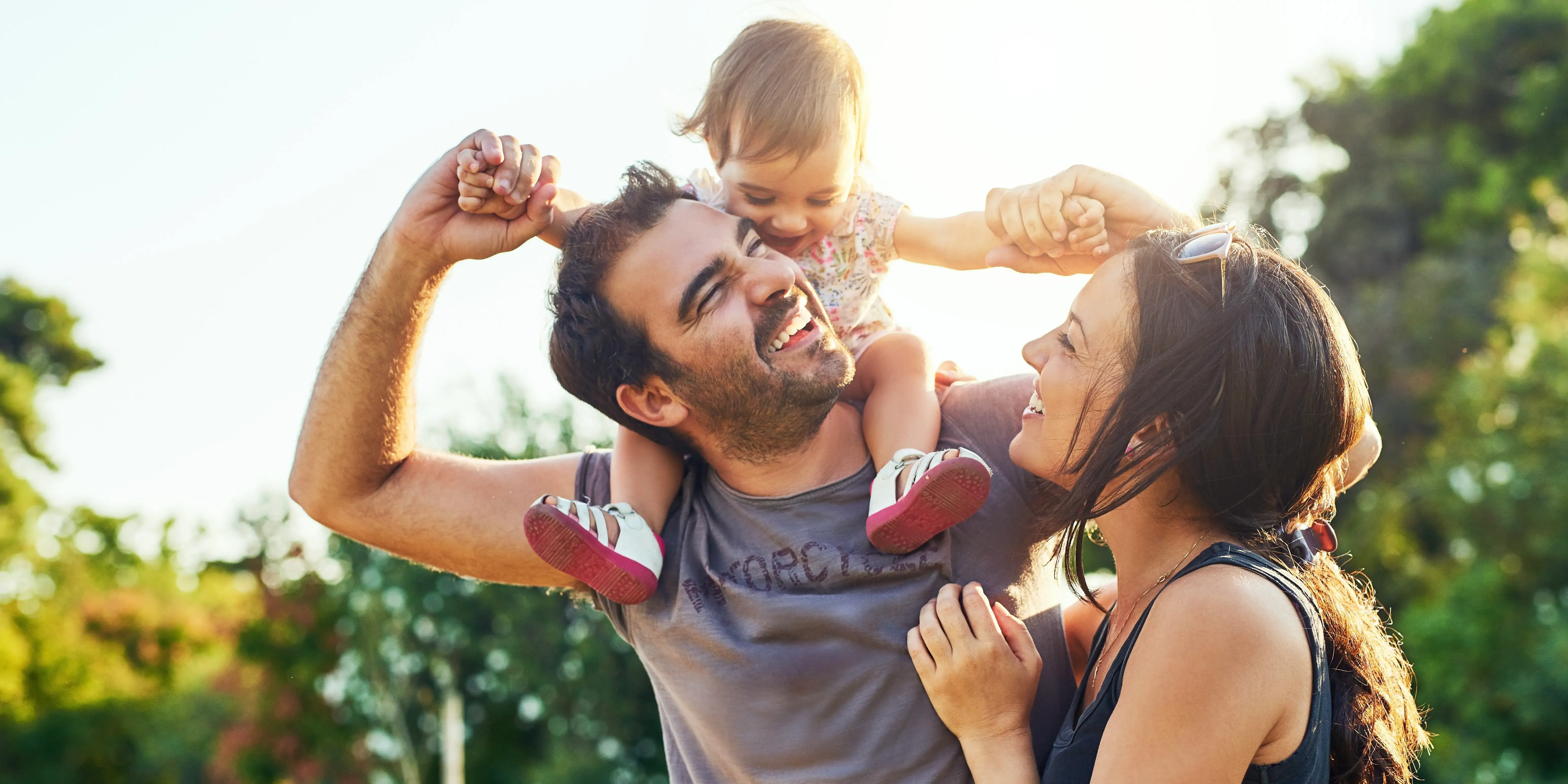 Familia feliz en un parque. Rodéate de naturaleza
