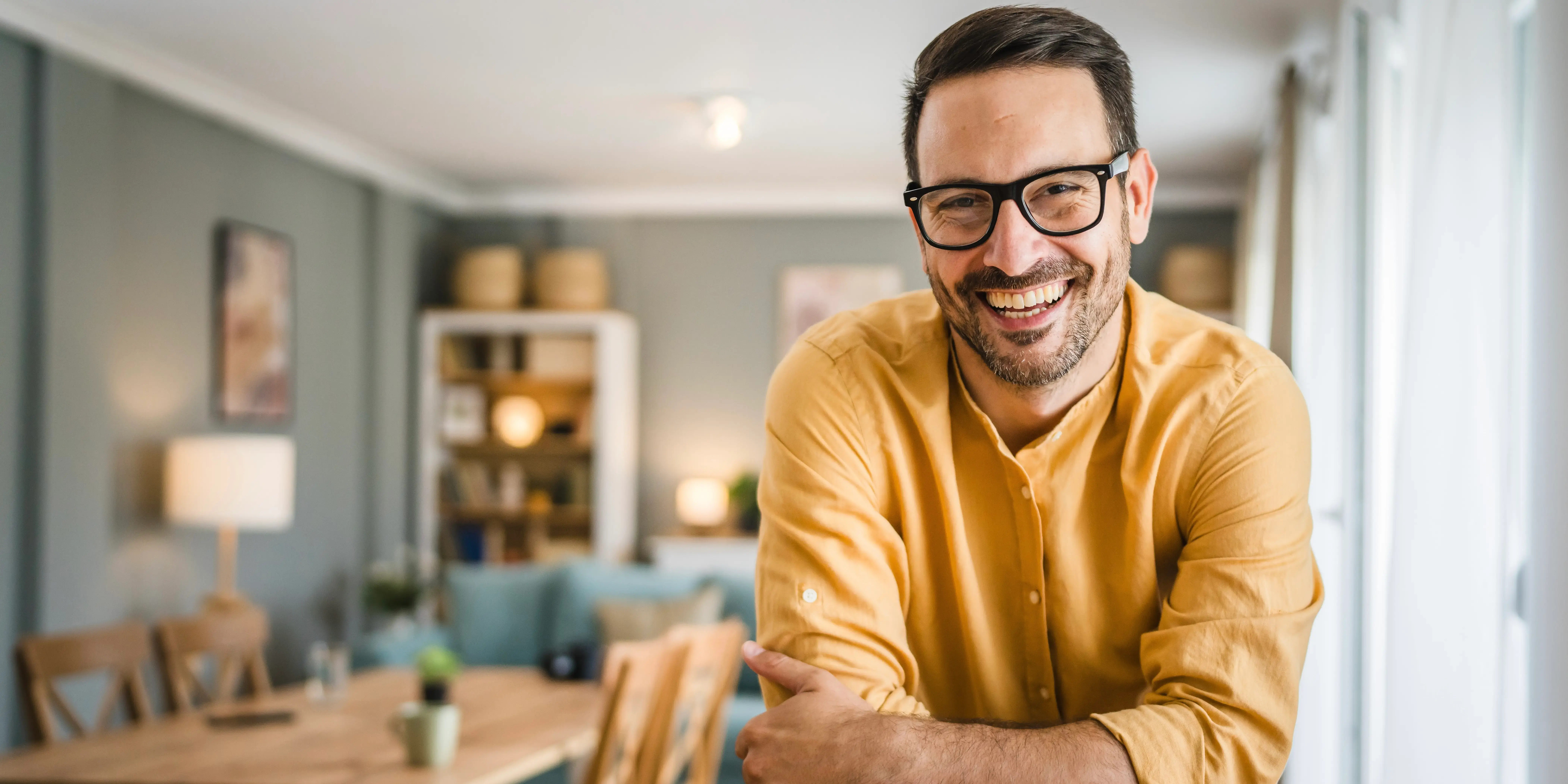 Hombre feliz en la sala de su casa. Bienestar emocional