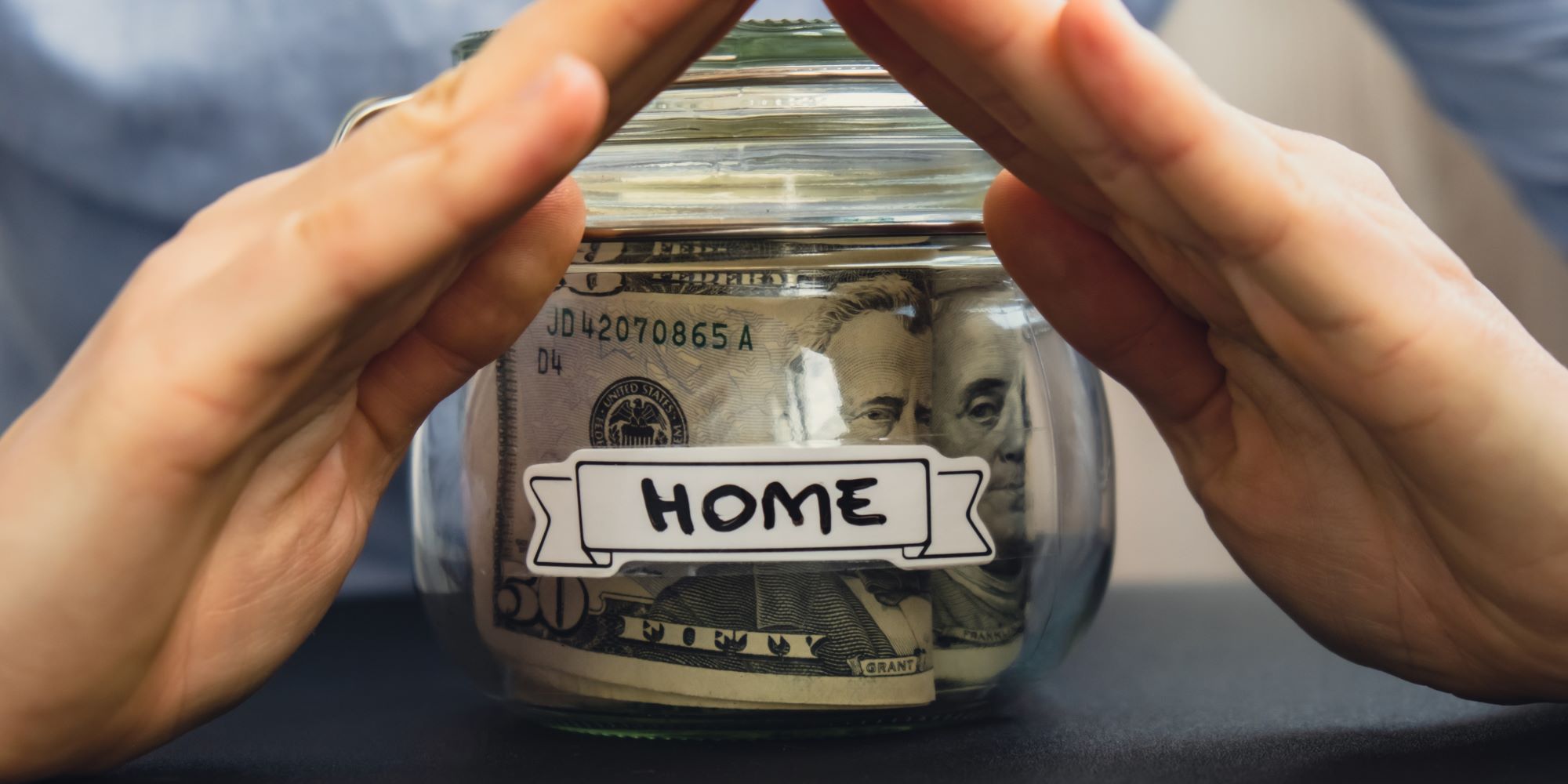 Jarra con una etiqueta que dice home. Representa los ahorros que hizo una persona para pagar la hipoteca d e su casa.