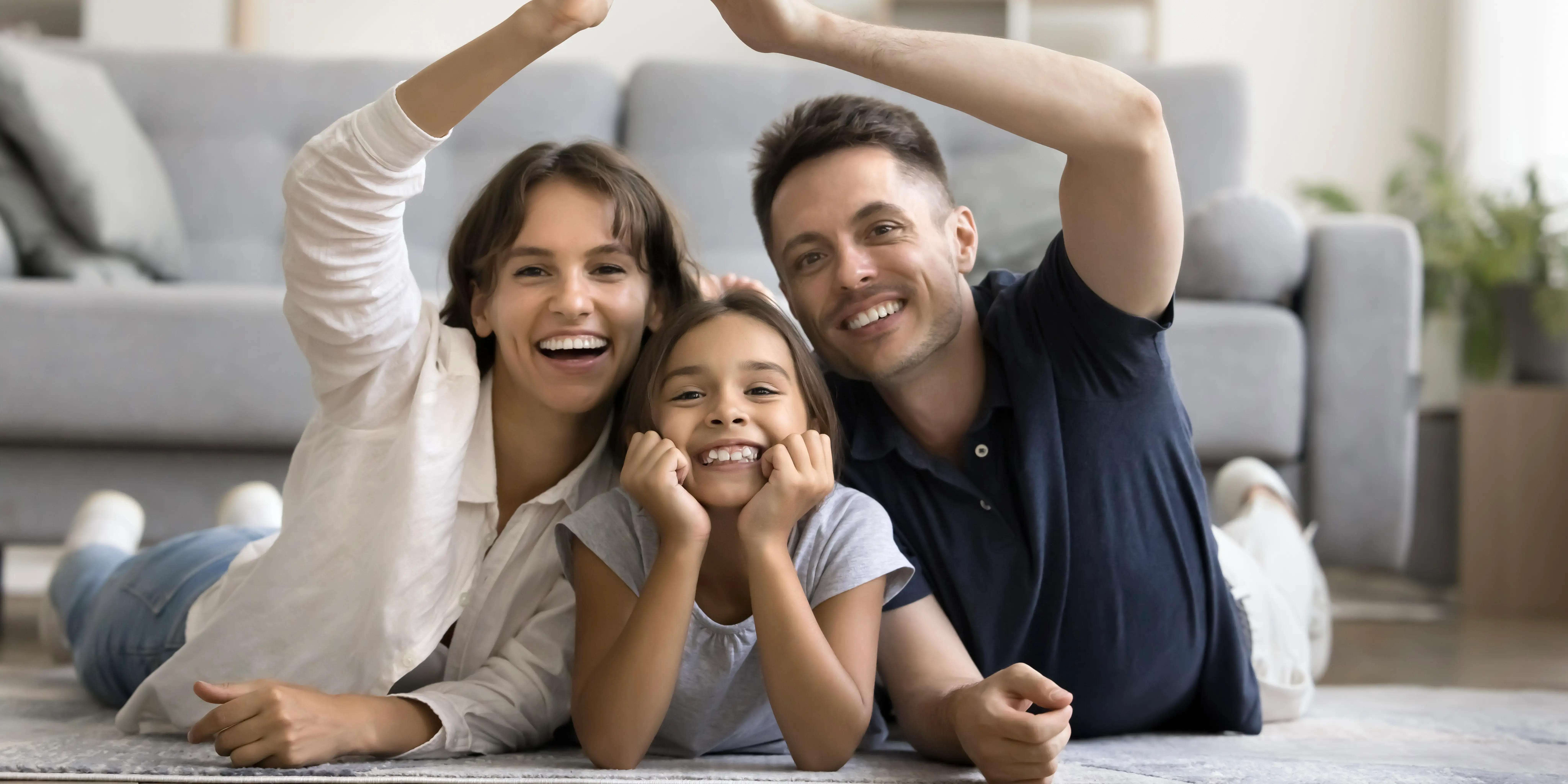 Papá y mamá formando el techo de una casa con sus brazos. Entorno ideal para ver crecer a tus hijos